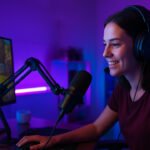 Streamer mulher jogando e transmitindo ao vivo em setup gamer iluminado com luzes neon.